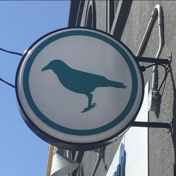 Round projecting blade sign installed by Denton Design.