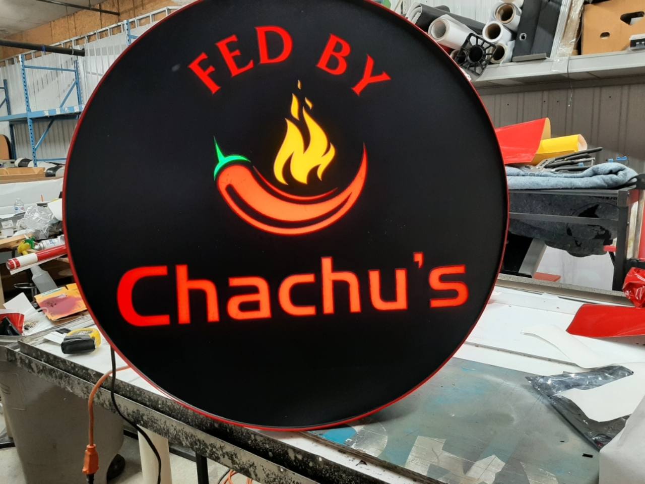 Fed By Chachu's illuminated round sign during fabrication at Denton Design.