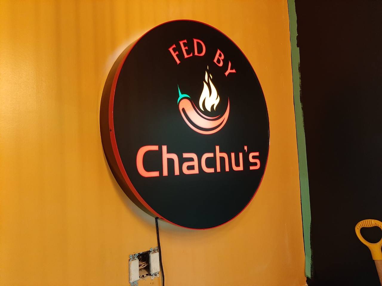 Fed By Chachu's illuminated round wall sign installed by Denton Design.